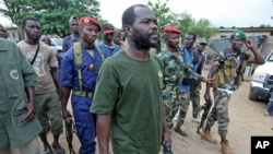 A man known as Commander Bauer, the chief of a group that calls itself the 'invisible commandos' and backs Alassane Ouattara, walks with his fighters in northern Abidjan's Abobo district, March 26, 2011