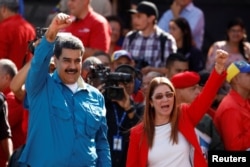 FILE - Venezuela's President Nicolas Maduro and his wife, Cilia Flores, greet supporters at a rally in Caracas, Jan. 23, 2018.