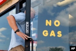A customer walks into an Exxon filling station and convenience store location where a sign on the door reads, "No Gas," Aug. 31, 2017, in Bedford, Texas. It’s getting harder to fill gas tanks in parts of Texas where some stations are out of fuel and pump costs are spiking.