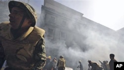 Egyptian army soldiers fight a fire believe to be set by hundreds of low-ranking police at a part of the security headquarters in Cairo, Egypt, February 23, 2011