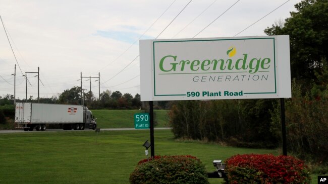 A semi-trailer truck passes the entrance to the Greenidge Generation power plant, Friday, Oct. 15, 2021, in Dresden, N.Y.