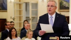 New Australian Prime Minister Scott Morrison is seen at his swearing-in ceremony as his wife Jenny looks on, in Canberra, Australia, Aug. 24, 2018.