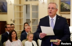 New Australian Prime Minister Scott Morrison is seen at his swearing-in ceremony as his wife Jenny looks on, in Canberra, Australia, Aug. 24, 2018.