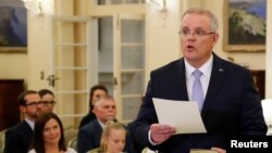 New Australian Prime Minister Scott Morrison is seen at his swearing-in ceremony as his wife Jenny looks on, in Canberra, Australia, Aug. 24, 2018.