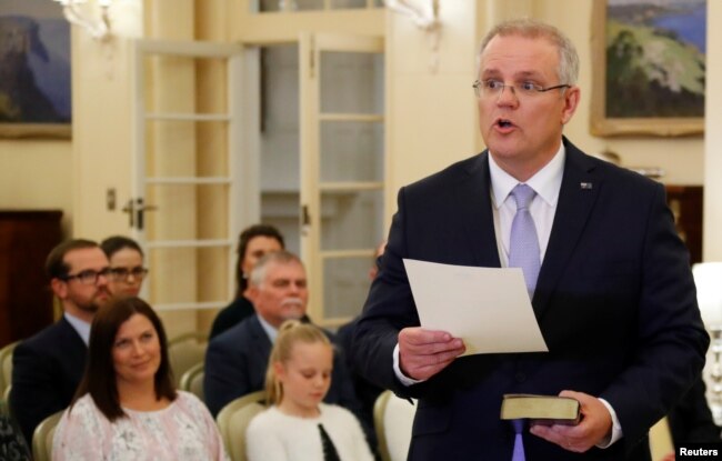 New Australian Prime Minister Scott Morrison is seen at his swearing-in ceremony as his wife Jenny looks on, in Canberra, Australia, Aug. 24, 2018.