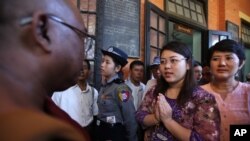 Student Chaw Sandi Tun, 25, speaks with a Buddhist monk after her hearing at court in Maubin, Myanmar, Tuesday, Nov. 24, 2015.
