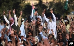 FILE - Supporters of the Pakistan Defense Council chant slogans at a rally against America, in Rawalpindi, Pakistan, Dec. 29, 2017. The Palestinian envoy attended the rally with Hafiz Saeed, the head of the hard-line Jamaat-ud-Dawa movement and a suspected terrorist.