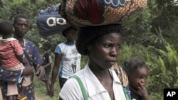 Refugees from Ivory Coast walk with their their belongings through Grand Gedeh county in eastern Liberia March 23, 2011.