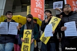 FILE -Hong Kong student leaders (L-R) Oscar Lai, Agnes Chow, Joshua Wong and Derek Lam speak as they arrive at the police headquarters in Hong Kong January 16, 2015.