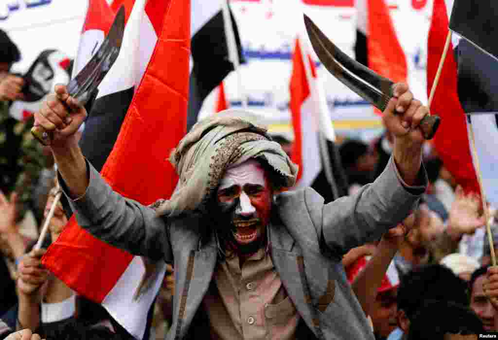 A man waves traditional daggers, or Jambiyas, as he attends with supporters of the Houthi movement and Yemen&#39;s former president Ali Abdullah Saleh a rally to mark two years of the military intervention by the Saudi-led coalition, in Sana&#39;a, Yemen.