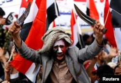FILE - A man waves traditional daggers, or Jambiyas, as he attends with supporters of the Houthi movement and Yemen's former president Ali Abdullah Saleh a rally to mark two years of the military intervention by the Saudi-led coalition, in Sanaa, Yemen March 26,