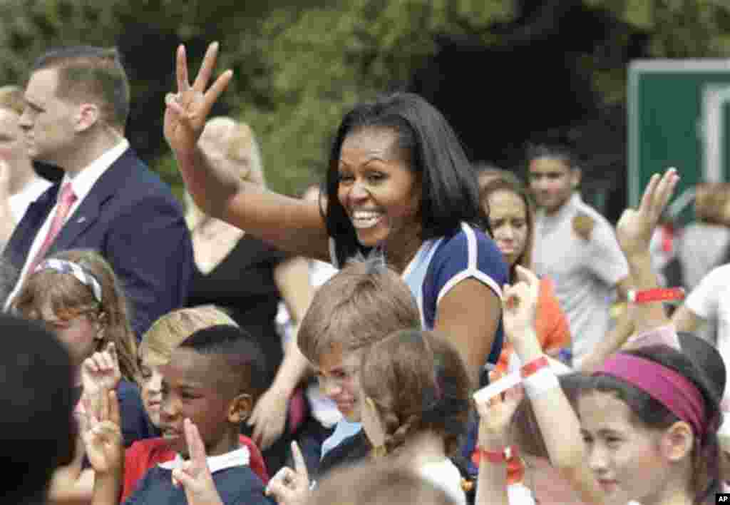 U.S. first lady Michelle Obama poses for photos with schoolchildren during a 'Let's Move!' event for about 1,000 American military children and American and British students at the U.S. ambassador's residence in London, ahead of the 2012 Summer Olympics, 
