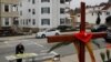 Seorang umat paroki mengambil daun palem di luar Gereja Katolik Sakramen Suci pada perayaan Minggu Palma di tengah wabah COVID-19 di Worcester, Massachusetts, 5 April 2020. (Foto: Reuters)