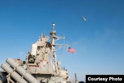 FILE - Image of Russian fly-over near guided-missile destroyer USS Donald Cook in Baltic Sea as provided by the U.S. Navy 6th Fleet.