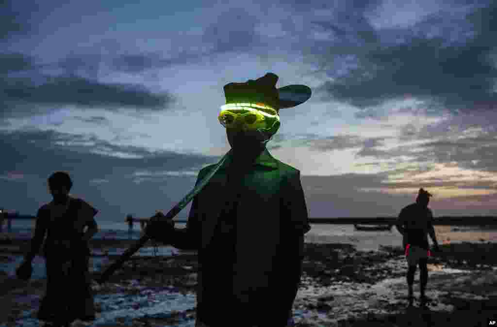 A boy from a fishing community posses for a picture along the shores of the Arabian Sea on the occasion of Narli Purnima Festival celebration in Mumbai, India.