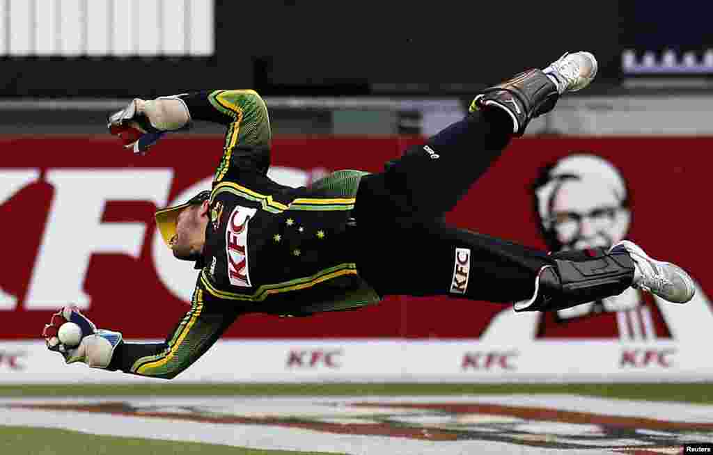 Australia&#39;s Matthew Wade dives to stop the ball during the Twenty20 international cricket match against Sri Lanka at the Melbourne Cricket Ground, Australia. 