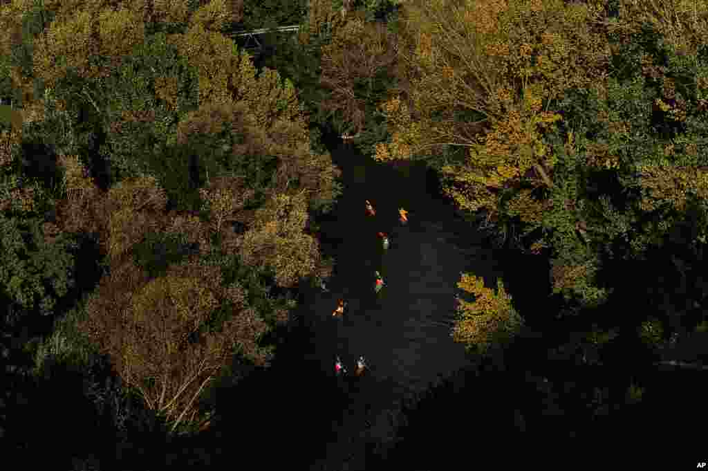 A group of paddlers makes its way along the Arga River as the sun sets in Pamplona, northern Spain, Oct. 13 2015.