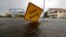 Floodwaters lap at a high water warning sign that was partially pushed over by Hurricane Florence on Oak Island, N.C., Sept. 15, 2018.