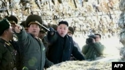 Screen grab shows North Korean leader Kim Jong-Un (C) pointing to a South Korean island during a trip to an artillery unit on Wolnae Island near the disputed maritime frontier with South Korea, March 12, 2012.