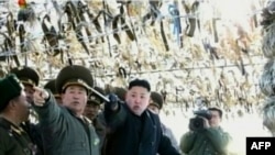 Screen grab shows North Korean leader Kim Jong-Un (C) pointing to a South Korean island during a trip to an artillery unit on Wolnae Island near the disputed maritime frontier with South Korea, Mar. 12, 2012.