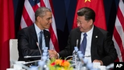 FILE - President Barack Obama (L) shakes hands with Chinese President Xi Jinping during their meeting on the sidelines of the United Nations Climate Change Conference, in Le Bourget, outside Paris, Nov. 30, 2015.