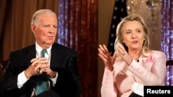 លោកស្រី Hillary Clinton អង្គុយ​នៅ​ក្បែរ​លោក James Baker ក្នុង​កិច្ចសន្ទនា​ស្តី​ពី​ការ​ទូត​នៅ​ក្រសួង​ការបរទេស​ក្នុង​រដ្ឋធានី​វ់ាស៊ីនតោន កាលពី​ថ្ងៃទិ២០ ខែមិថុនា ឆ្នាំ២០១២។