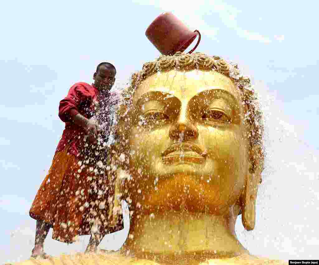 ព្រះសង្ឃសម្អាតរូបសំណាក់ព្រះពុទ្ធរូបនៅមុនពិធីបុណ្យវិសាខបូជានៅអារាមមួយក្នុងក្រុង Bophal ប្រទេសឥណ្ឌា។ 