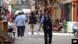 In this August 2, 2011 photo, a policeman patrols near the site of an attack in Kashgar in China's far western Xinjiang Uigur Autonomous Region. 