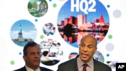 FILE - New Jersey Sen. Cory Booker (R) speaks as New Jersey Gov. Chris Christie stands behind him in Newark, N.J., Oct. 16, 2017, after New Jersey lawmakers announced they are submitting a bid to Amazon that Newark would be the best location for the company's planned second headquarters. 