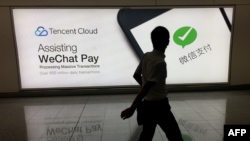 Un homme marche devant une publicitré WeChat de la compagnie chinoise Tencent, à l'aéroport international de Hong Kong, Chine, 21 août 2017. 