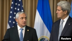 Guatemala’s President Otto Perez Molina, left, and U.S. Secretary of State John Kerry discuss immigration while in Panama City, July 1, 2014.