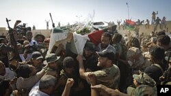 Libyan men carry a coffin and chant slogans during the funeral of rebels' slain military chief Abdel Fattah Younes in the rebel-held town of Benghazi, July 29, 2011