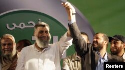 FILE - Leading member of the Islamic Jama'a Assem Abdel Maged (L) gestures with other leaders during a protest around the Raba El-Adwyia mosque square in the suburb of Nasr City, Cairo, June 28, 2013. 