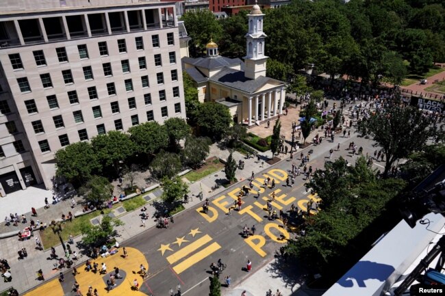 A sign painted by protesters stating "Defund the Police" is seen next to a Black Lives Matter sign as people demonstrate against the death in Minneapolis police custody of George Floyd, near the White House in Washington, U.S., June 7, 2020. (REUTERS/Josua Roberts)