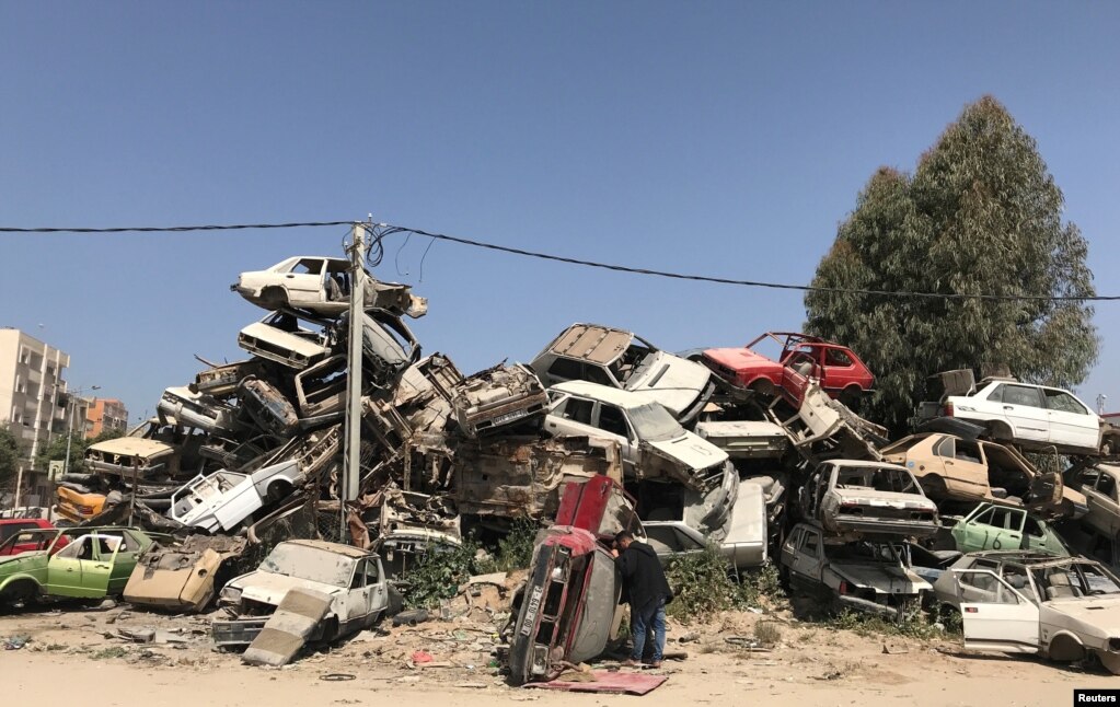 팔레스타인 남성이 이스라엘과 가자지구 가자시티 동부 경계에 쌓인 폐차 더미를 살피고 있다.