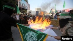 Gazze'nin güneyinde İsrail karşıtı gösteride Davut Yıldızı mankenini yakan maskeli Hamas üyeleri