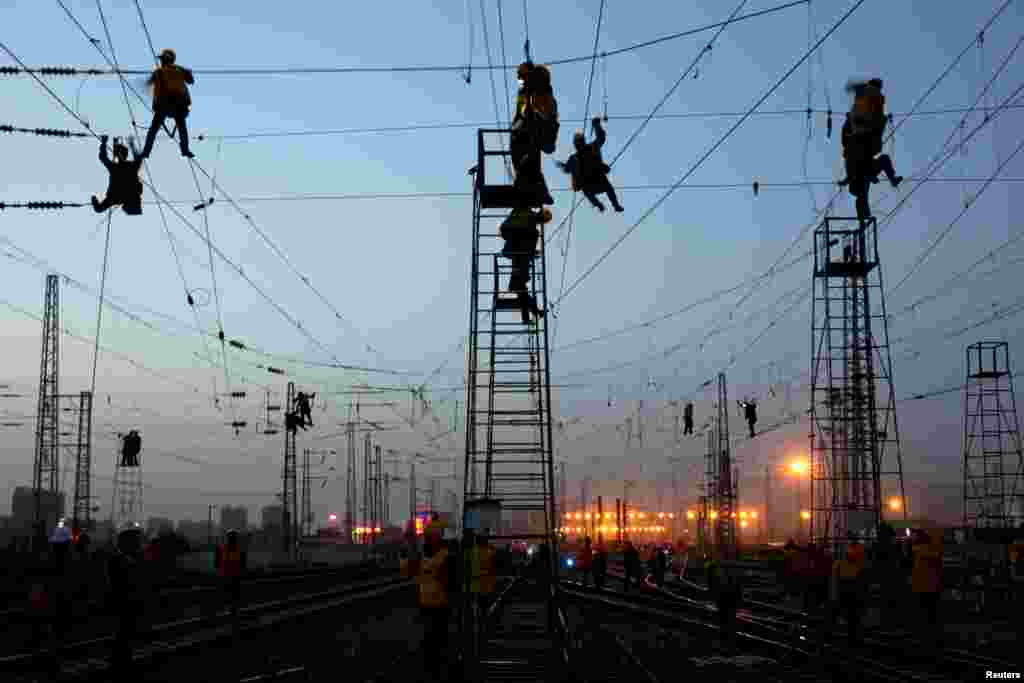 Workers are seen in silhouette at the Korla railway station under construction in Bayingolin Mongol Autonomous Prefecture, Xinjiang Uighur Autonomous Region, China, Oct. 31, 2018.