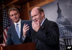 Sen. Jeff Flake, R-Ariz., left, and Sen. Chris Coons, D-Del., talk to reporters after making speeches on the Senate floor calling for a resolution to back the U.S. intelligence community findings that Russia interfered in the 2016 election and calling for other responses to the meddling, on Capitol Hill in Washington, July 19, 2018.