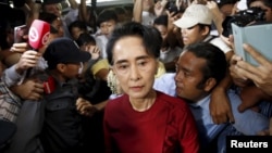 ຜູ້ນຳພັກສັນນິບານແຫ່ງຊາດເພື່ອປະຊາທິປະໄຕ ຫຼື National League for Democracy (NLD) ທ່ານນາງ Aung San Suu Kyi ເດີນທາງໄປເຖິງໜ່ວຍປ່ອນບັດ ເພື່ອລົງຄະແນນສຽງ ໃນລະຫວ່າງການເລື້ອກຕັ້ງໃຫຍ່ ໃນນະຄອນ Yangon, ວັນທີ 8 ພະຈິກ 2015.