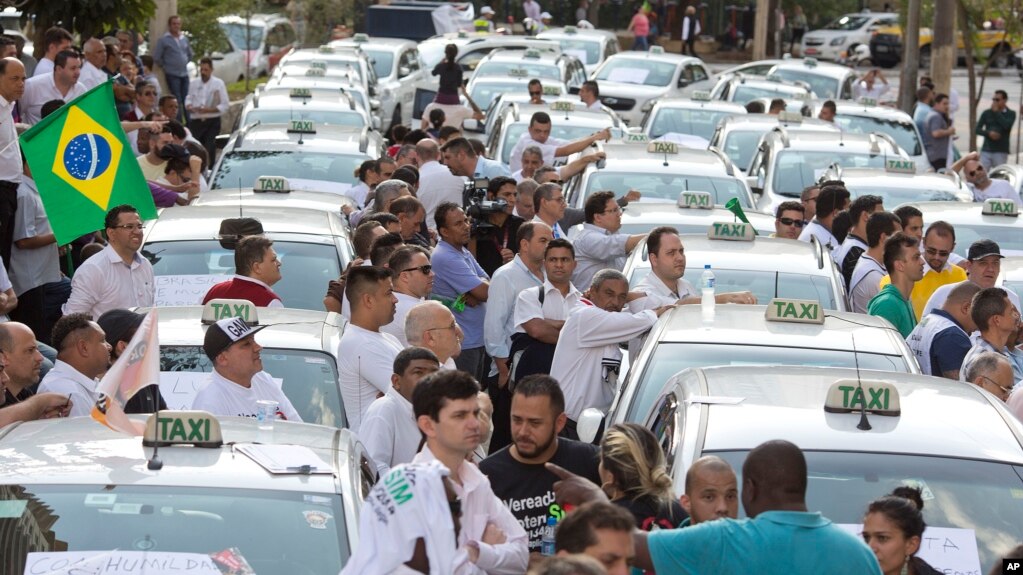 Taxi drivers block a street to protest the Uber ride-sharing service outside city council headquarters in downtown Sao Paulo, Brazil, Sept. 9, 2015.