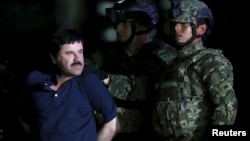 Joaquin "El Chapo" Guzman is escorted by soldiers during a presentation at the hangar belonging to the office of the Attorney General in Mexico City, Mexico, Jan. 8, 2016. 