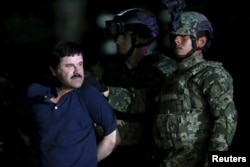 Joaquin 'El Chapo' Guzman is escorted by soldiers during a presentation at the hangar belonging to the office of the Attorney General in Mexico City, Mexico, Jan. 8, 2016.