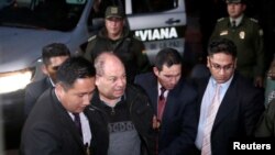 El ex ministro de gobierno boliviano Carlos Romero es escoltado por las fuerzas de seguridad durante su arresto como parte de una investigación por presunta corrupción, en La Paz, Bolivia, el 14 de enero de 2020.