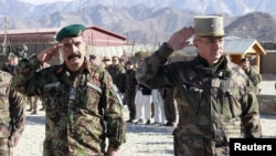 French General Eric Hautecloque Raysz (R) and his Afghan counterpart General Mohammad Zaman Waziri salute during handover ceremony, November 20, 2012.