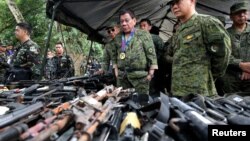 Philippine President Rodrigo Duterte inspects firearms together with Eduardo Ano, Chief of Staff of the Armed Forces of the Philippines (AFP), during his visit at the military camp in Marawi city, southern Philippines, July 20, 2017.