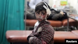 An injured boy waits inside a field hospital after what activists said were airstrikes and shelling by forces loyal to Syria's President Bashar al-Assad in the Douma neighborhood of Damascus, April 22, 2015.
