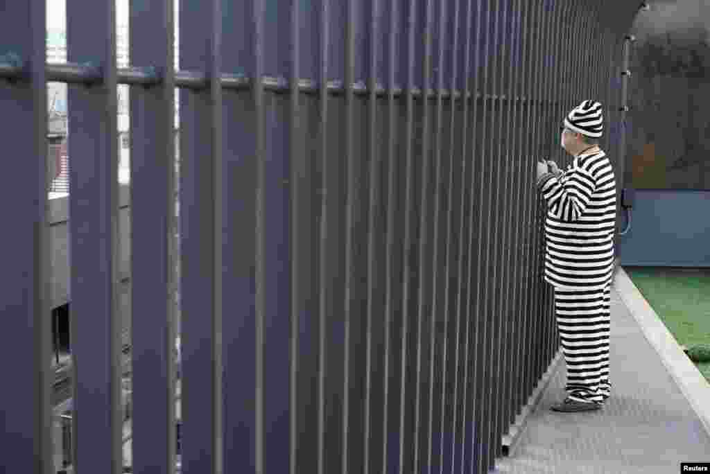 A hotel guest wearing prisoner uniform poses for photo on the deck of the Sook Station BangkokÕs first prison-themed hostel, Thailand.