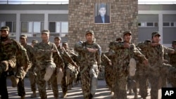 Soldados afganos hacen ejercicio bajo una foto del presidente Hamid Karzai, quien se niega a firmar un pacto de seguridad con Estados Unidos.
