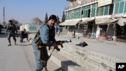 一名阿富汗警察星期三在喀布爾一家銀行門前看守著一名自殺爆炸手的屍體﹐他企圖進入這家銀行。