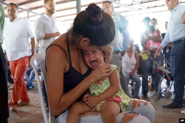 Una mujer venezolana sostiene a una niña en un puesto de salud para migrantes en Cúcuta, a lo largo de la frontera de Colombia con Venezuela, el lunes 16 de julio de 2018.